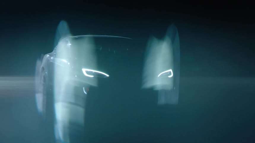 A sleek car driving down a dark road
