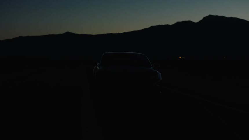A car is driving at night blinking it's lights