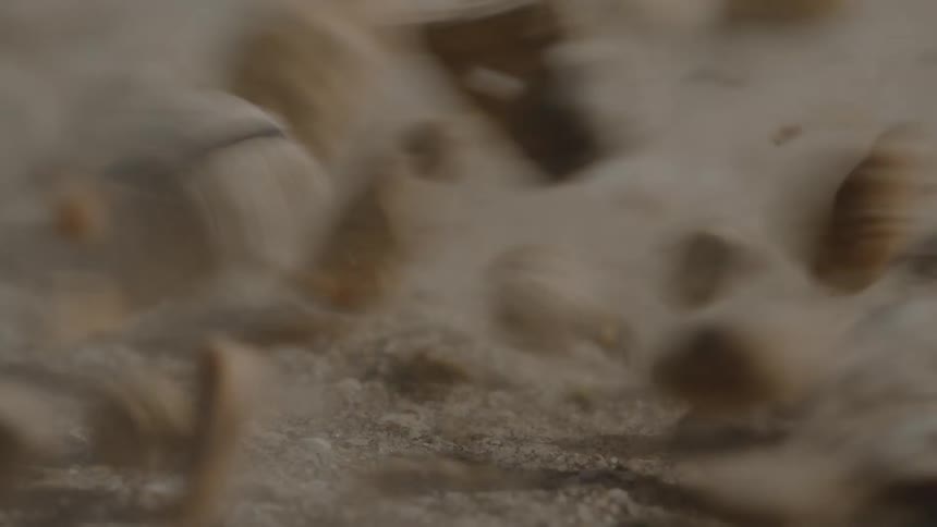 Water splashes followed by small rocks and pebbles falling onto dry ground