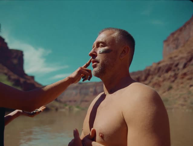 The woman puts mud on the mans face