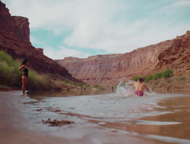 The man runs and jumps in the water