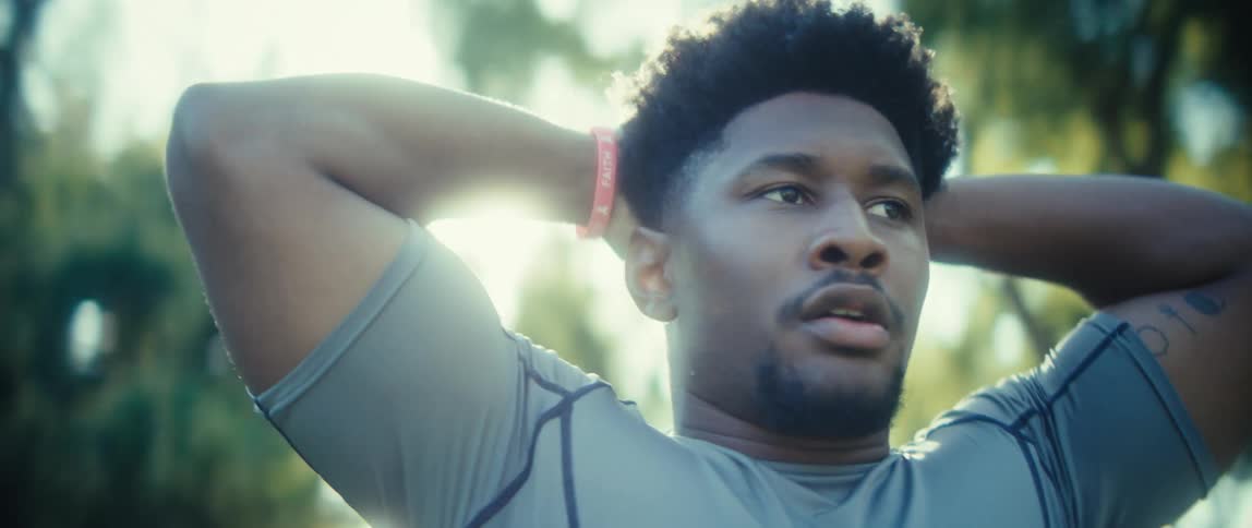 Black man sweating and exhaling outdoors with trees on the background during day time
