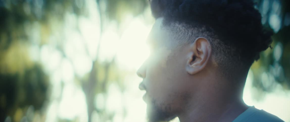 Black man looking around with a nervous face expression outdoors during day time