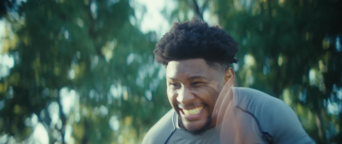 With an intense expression a determined athlete explodes into a sprint outdoors