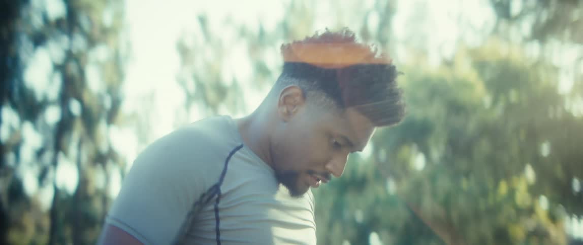 An athlete catches his breath and looks up with determination during an outdoor workout