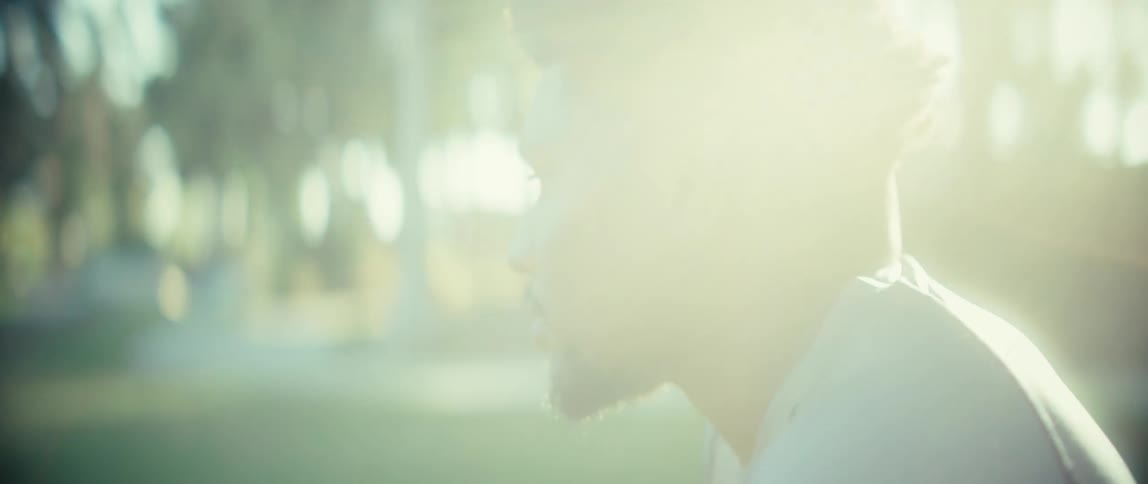 The video is a closeup shot of a mans face showing him taking a deep breath and exhibiting intense focus or exhaustionthe camera then pans down and follows him as he bends over and turns away suggesting he is getting ready to start or i