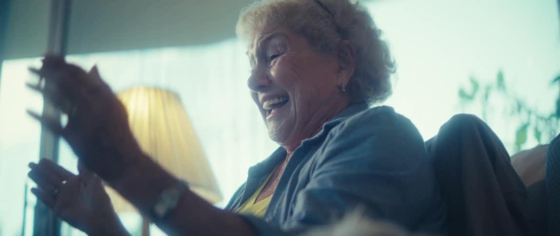 Elderly woman clapping next to a dog
