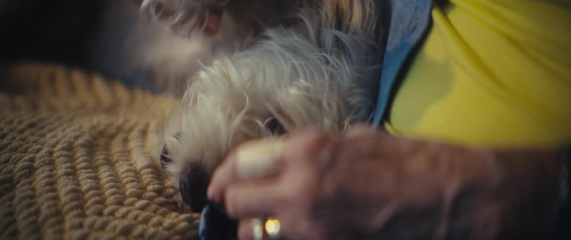 The woman is petting her dog