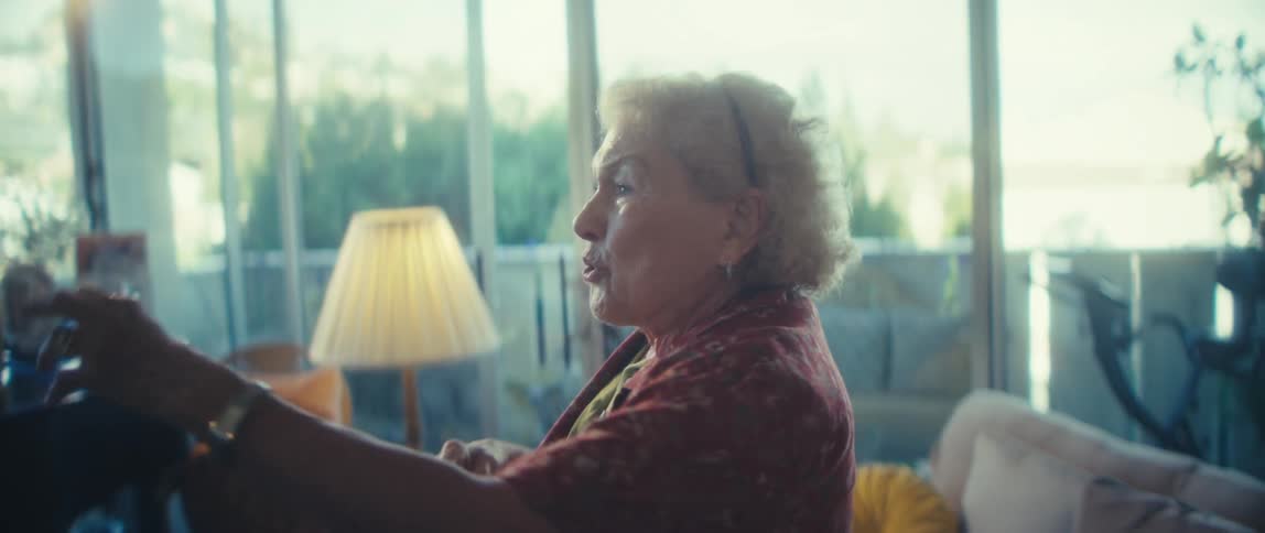 Elderly woman smiling and dancing joyfully in the living room