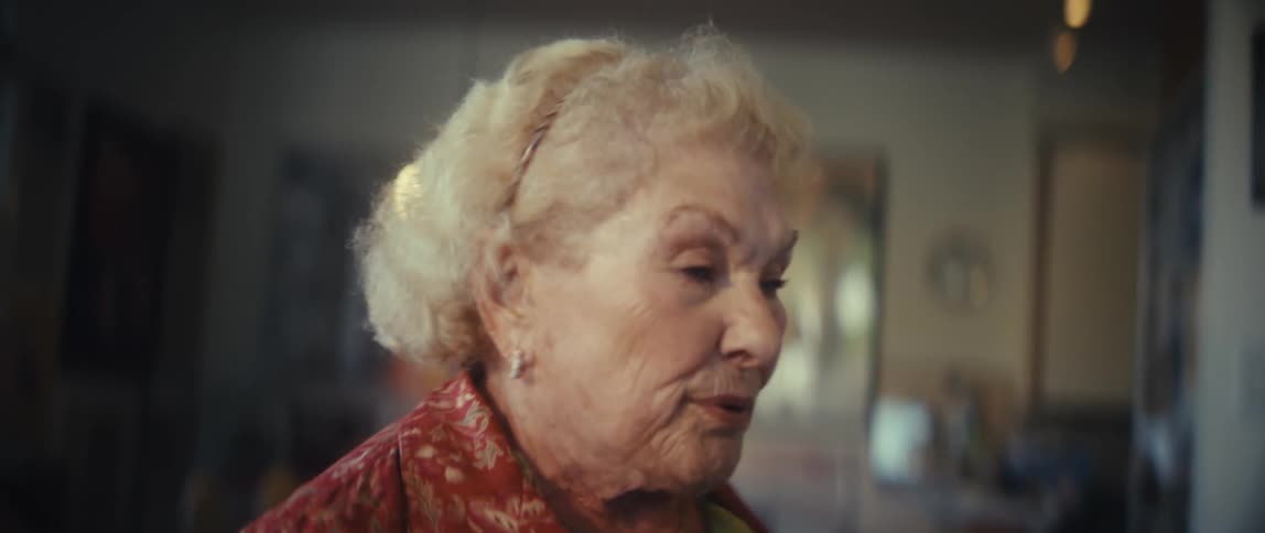 Elderly woman smiling and moving as if she were dancing