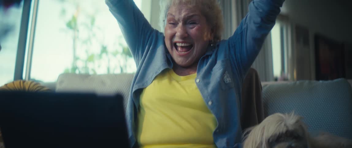 Elderly woman mimes punching someone while watching a match on her tablet then celebrates
