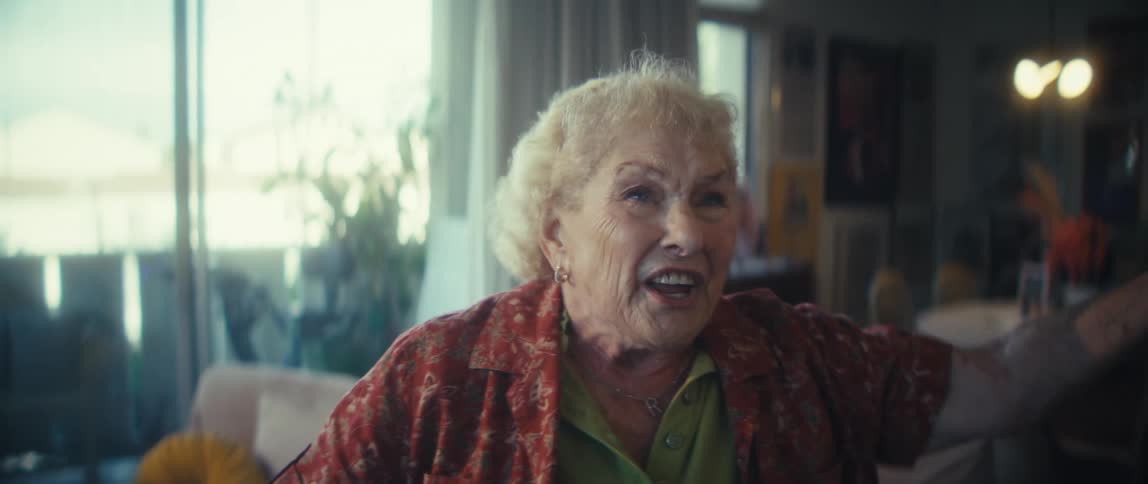 Filled with joy an elderly woman sings and dances enthusiastically in her living room