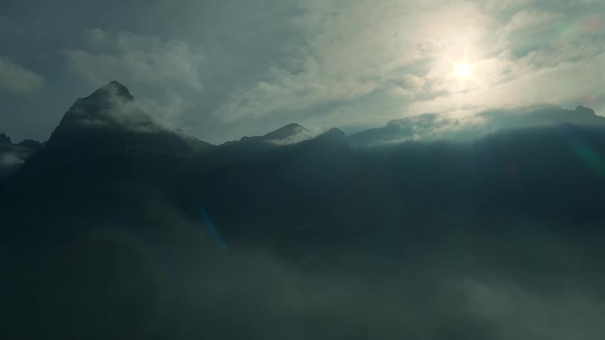 Fog and clouds cover the mountain peak