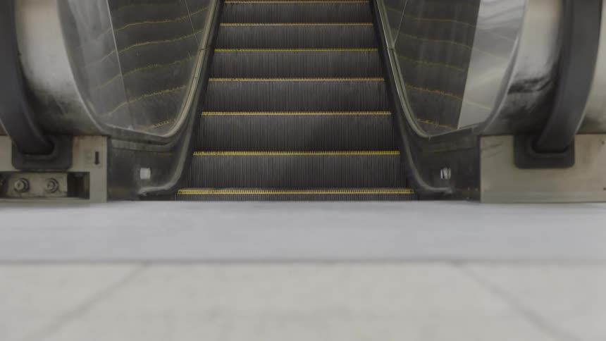 Empty escalator seen from below in an indoor setting