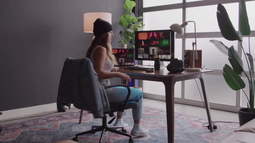 The woman gets up from the desk and walks away