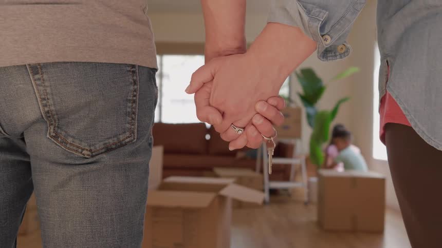 The parents hold hands while watching their children