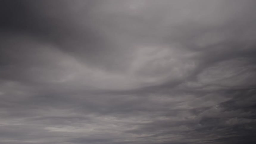 The video consists of a single shot showing a sky completely filled with dark turbulent storm cloudsthe heavy grey clouds move slowly suggesting an impending storm or severe weather