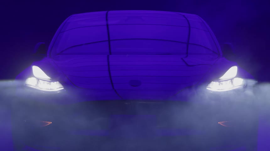 The video is a frontfacing shot of a car with its headlights illuminated in a dark stylized settingthe car which is visible through a covering that is outlined in neon blue light is shrouded by smoke or fog near the ground