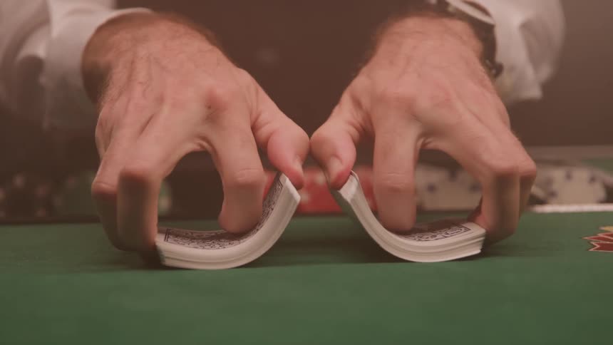 A man at a casino table counts cards ready to play