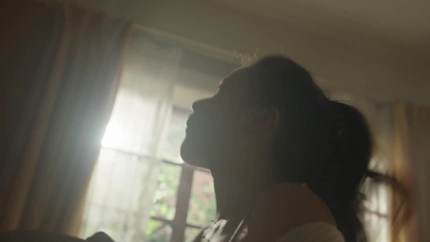 Woman dances while eating at home during the daytime