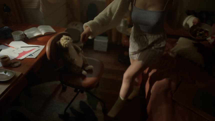 Woman dances in her bedroom while eating at home during the daytime