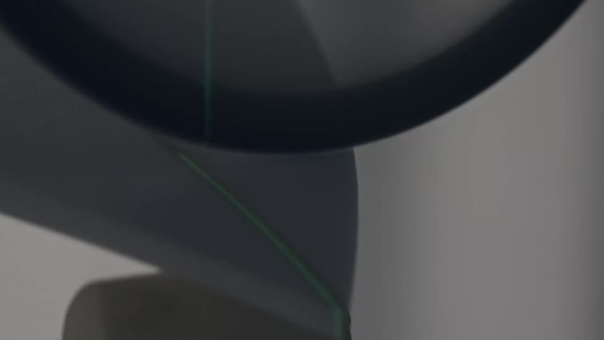 Translucent tape passes over a metallic roller in a soft closeup