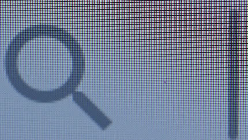 A close up of a computer screen shows the rgb pixel grid with a gray magnifying glass search icon