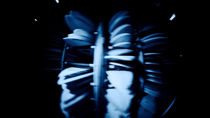 A fisheye view shows stacks of chairs lit in blue inside a dark room forming a dramatic ribbed radial pattern
