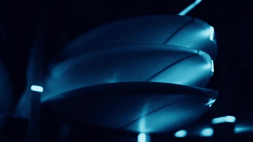 Stacked surfboards under soft light