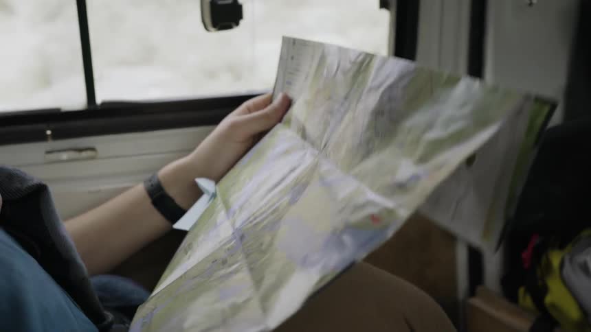 A person looks at a map inside a van