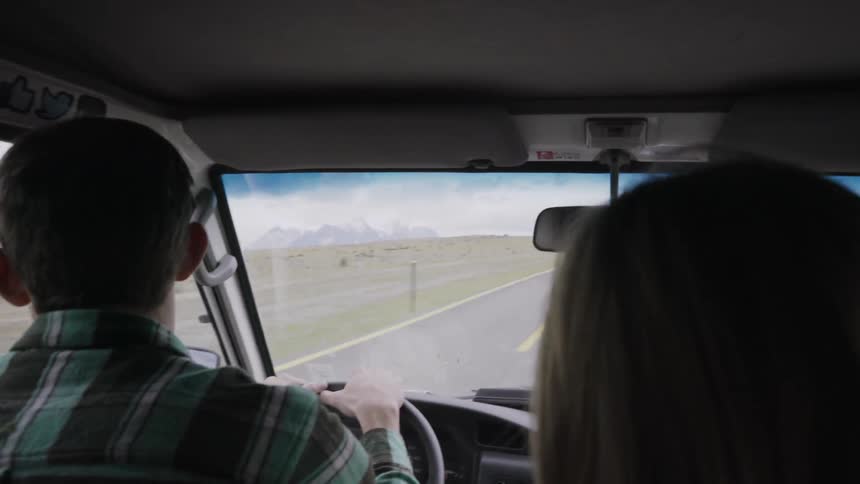 People are driving down a road on a cloudy day