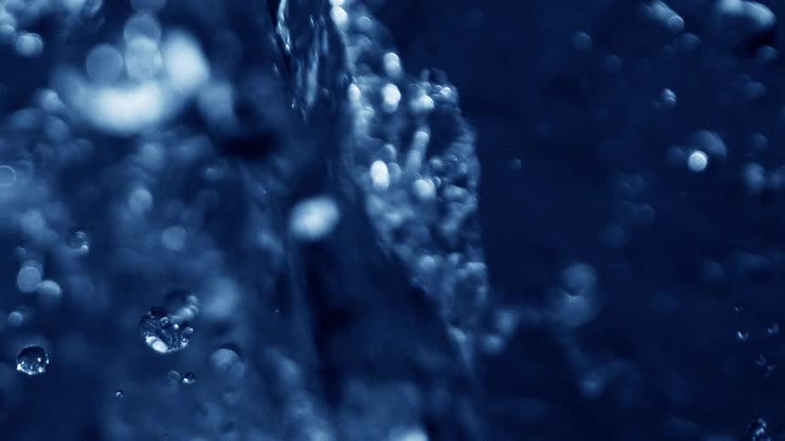 Water flows rapidly forming bubbles and splashes as it moves with energy and motion