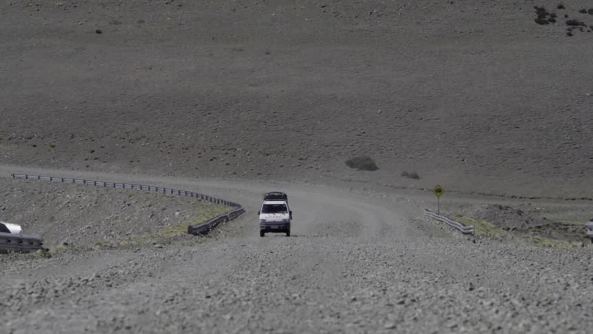 Vehicle driving towards the camera on a long dirt road