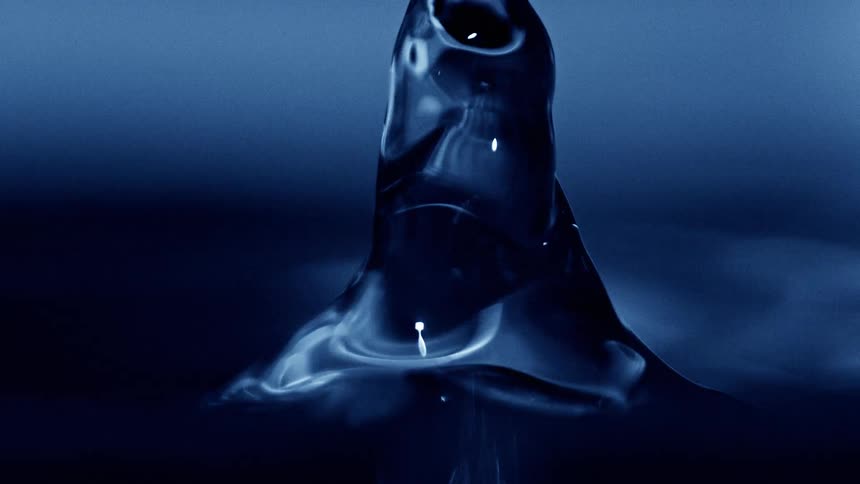 Water droplet rising after impact forming a liquid column under blue light