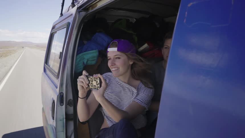 A woman holding her phone in a moving van
