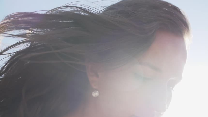 Woman smiling while the wind blows through her hair