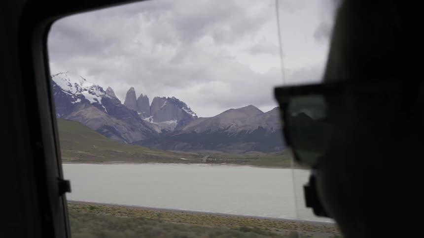A person is riding in a vehicle by a lake