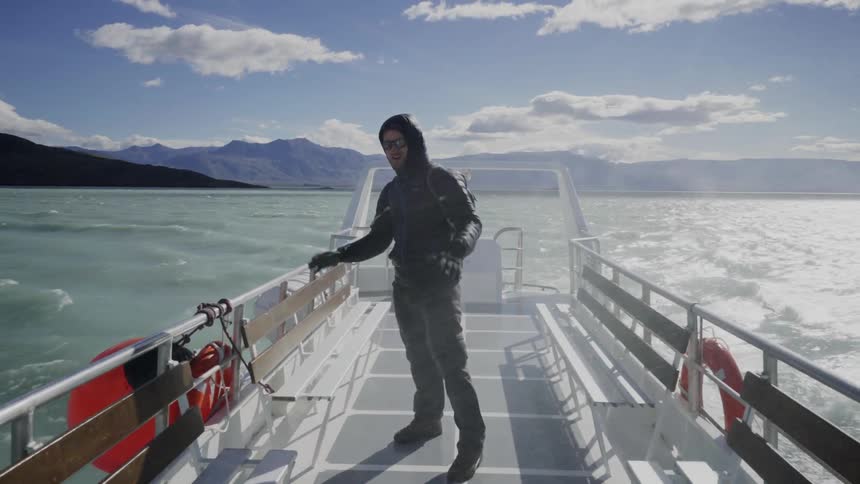 Man on a boat smiling as he gets sprayed with water