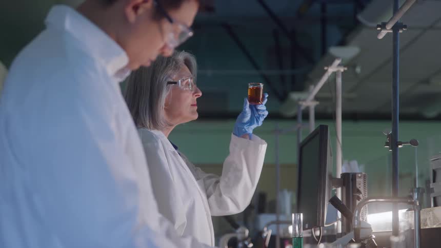A male and female scientist working with chemicals in a laboratory