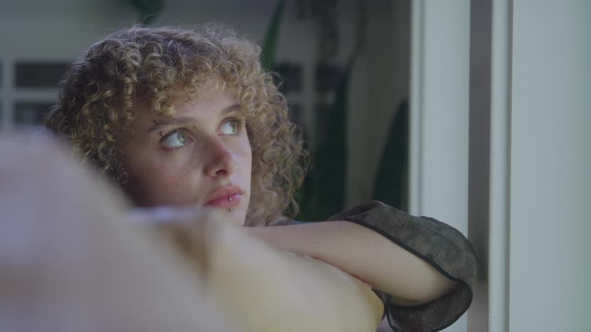 The girl is looking out the window