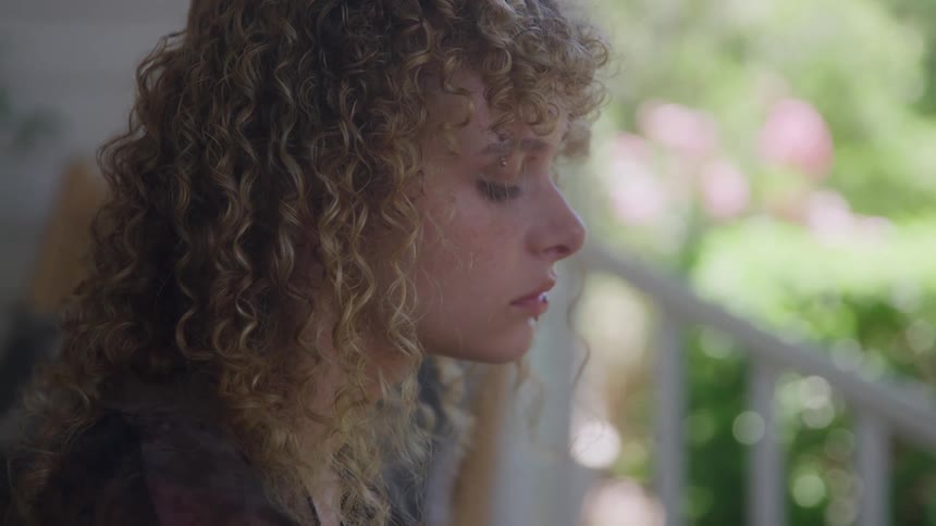 Close up portrait of a young woman sitting outdoors during daytime