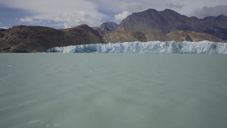 Murky gray water with mountains in the distance