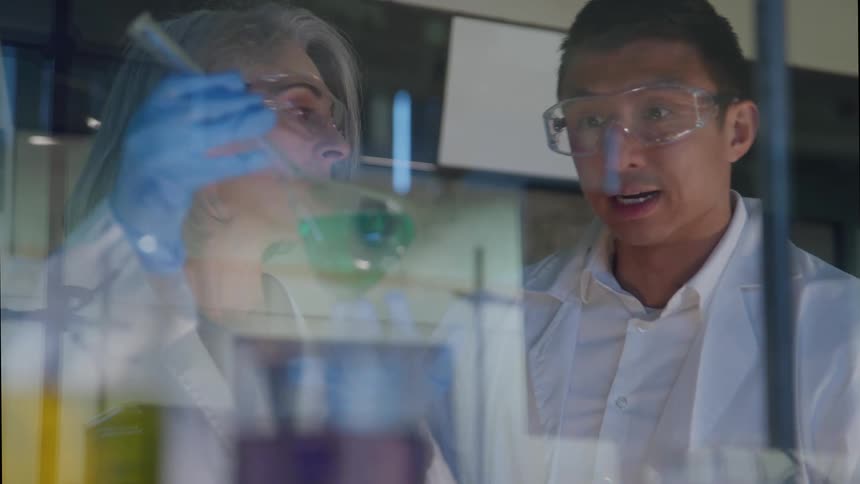 Two scientists closely examining a test tube in a laboratory