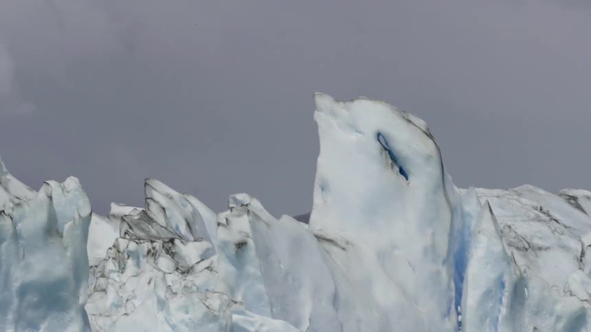 An iceberg sets among the gray clouds
