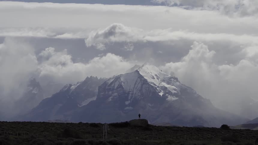 A hiker views a snowy mountain peak
