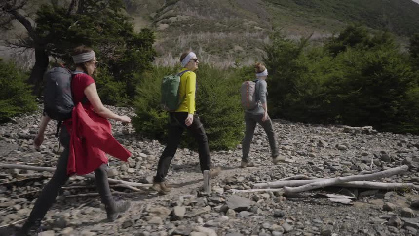 Three women walk down a rocky path