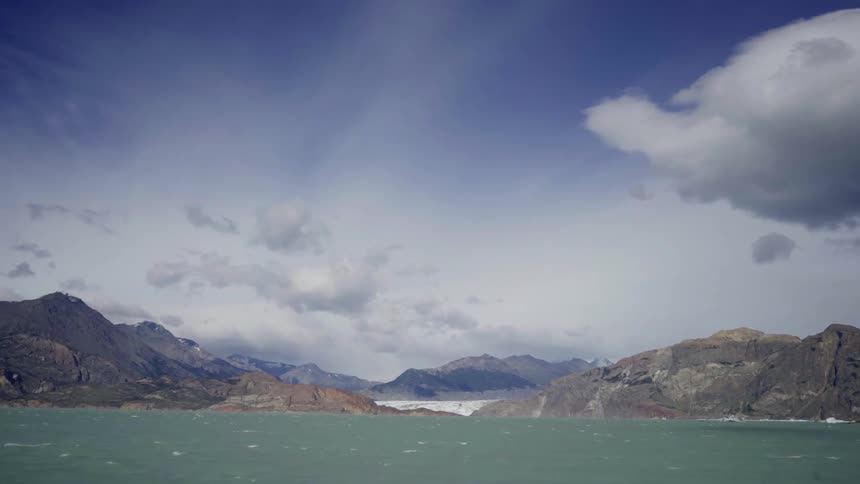 Clouds hover over mountains along a coastline
