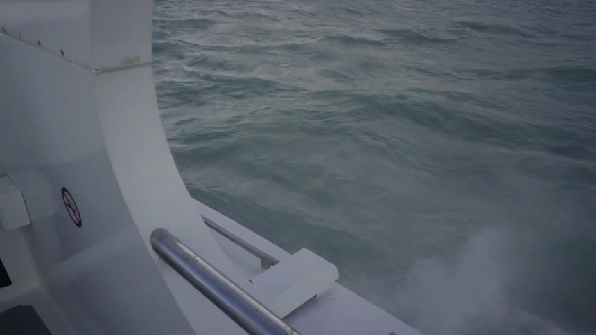A boat is moving in the water splashing waves