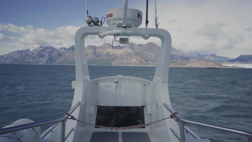 A boat traveling towards some mountains