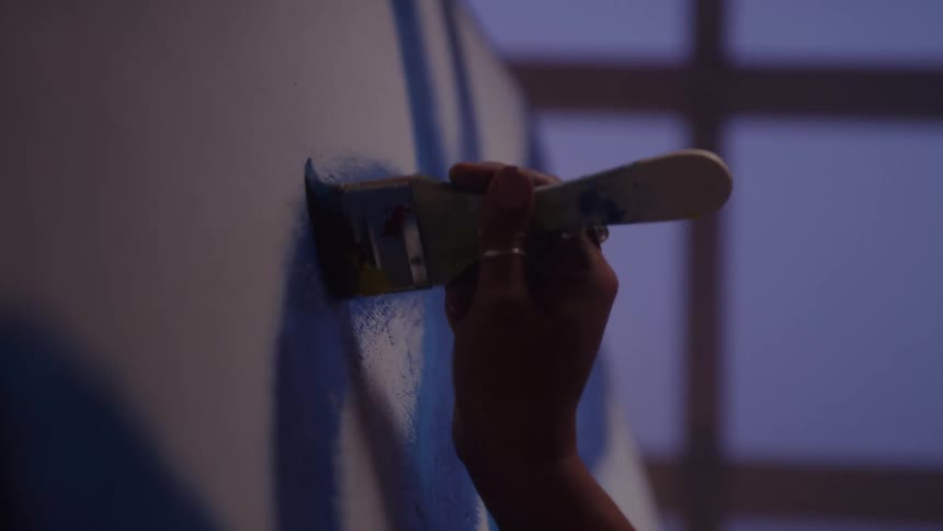 The woman paints on the canvas